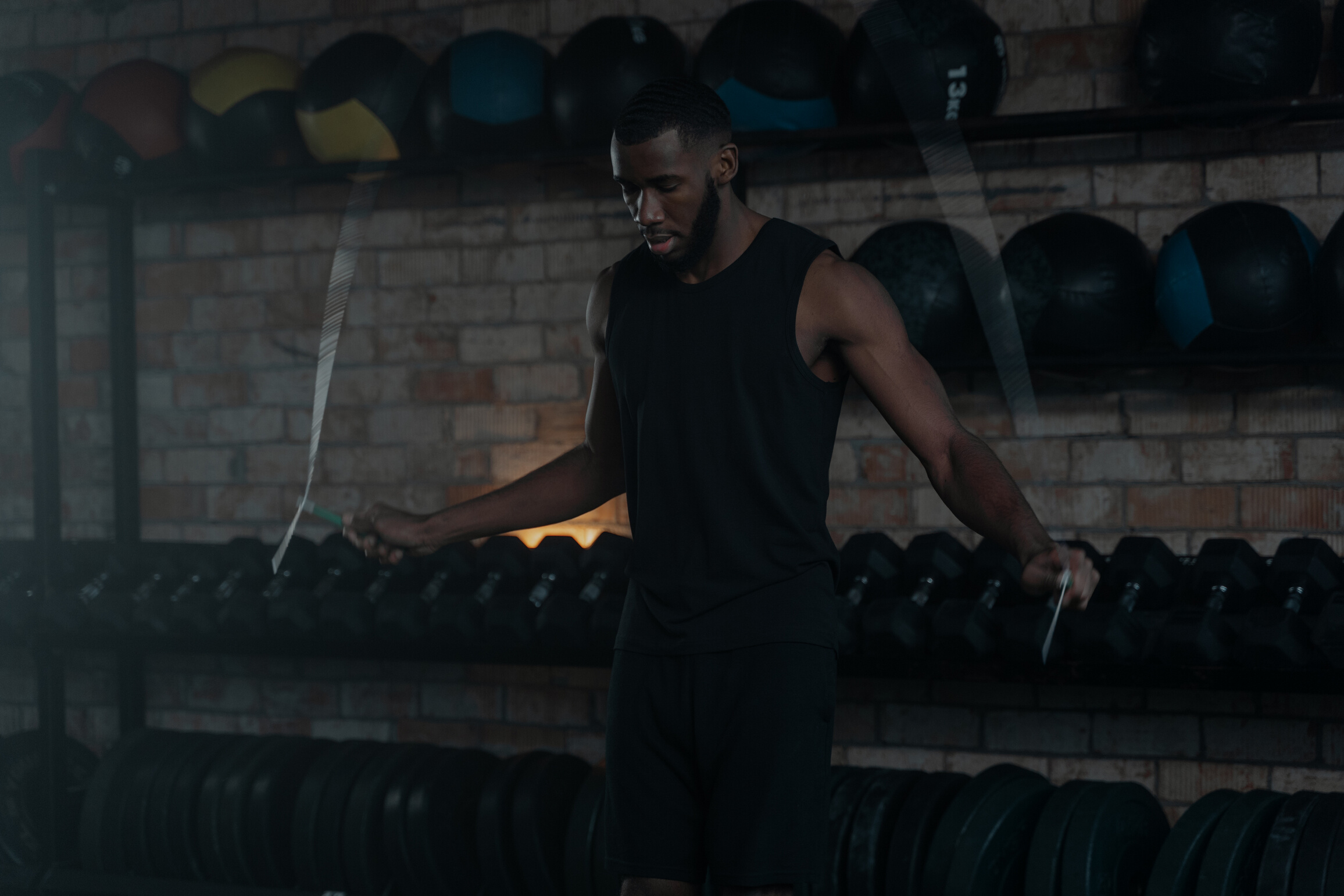 A Man in Black Tank Top Exercising in the Gym